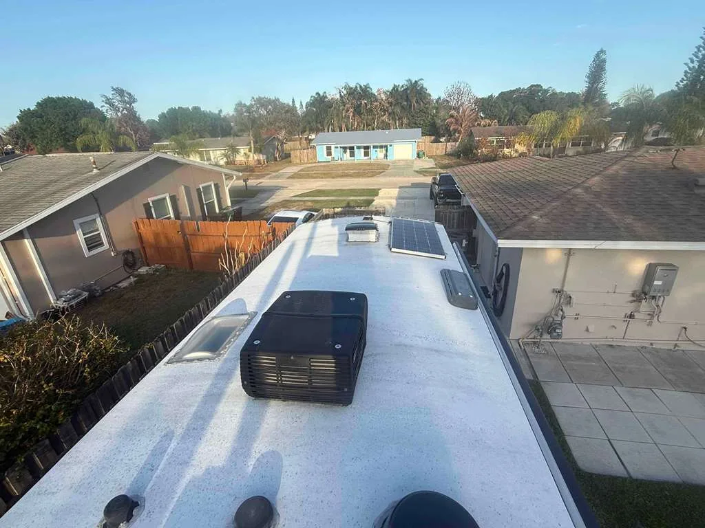 Heritage RV technician replacing a rooftop AC unit on an RV at a Florida campground
