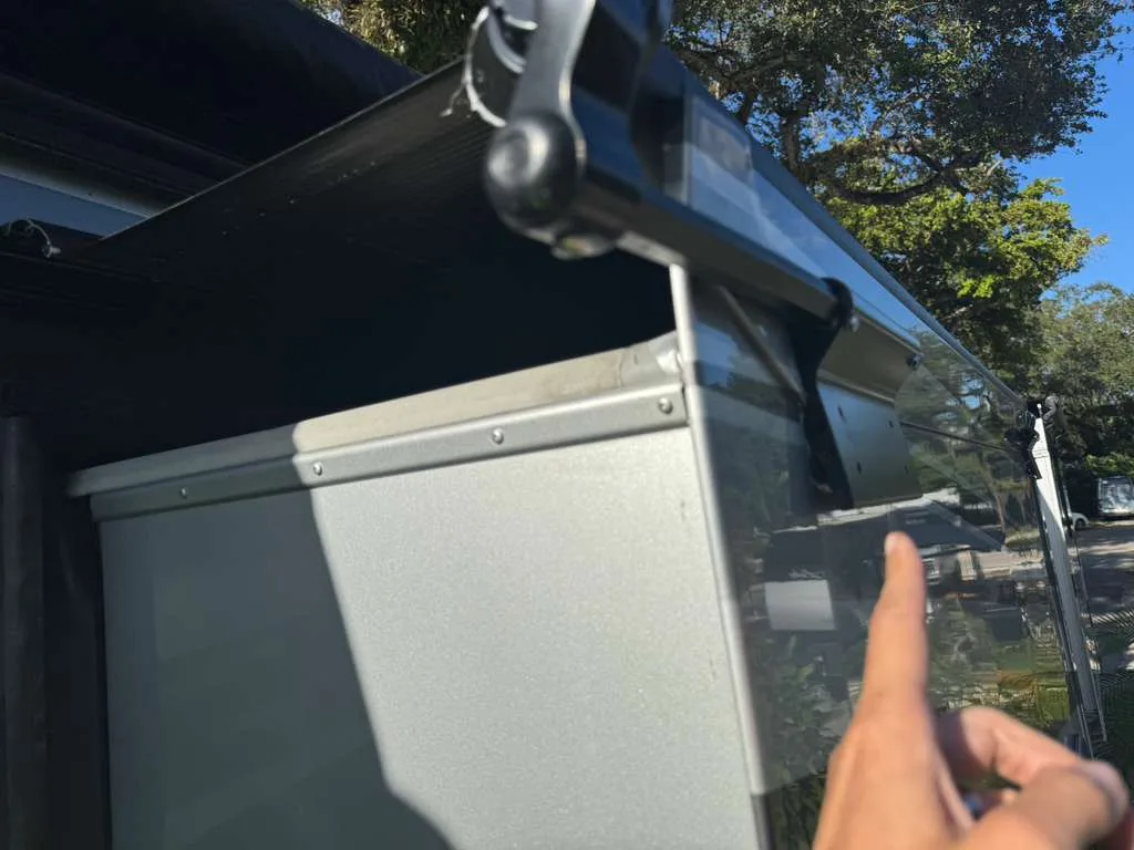 Broken RV awning arm bracket from wind damage being replaced