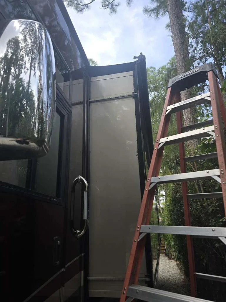 Heritage RV technician working on a stuck slide-out at a Florida campsite